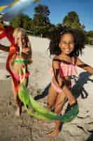 Бесплатное фото Девушки играют на пляже в полный рост