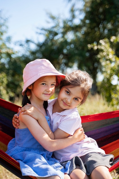 Girls playing outdoors together and sitting in hammock