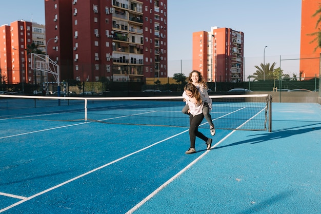 Girls playing on rooftop with tennis field