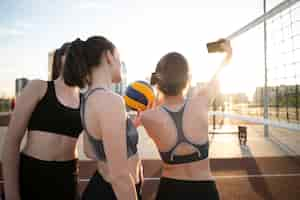 Free photo girls playing volleyball and taking selfie