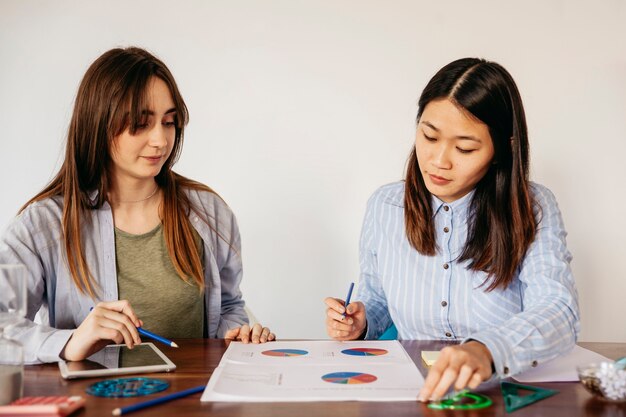 Girls researching charts on table