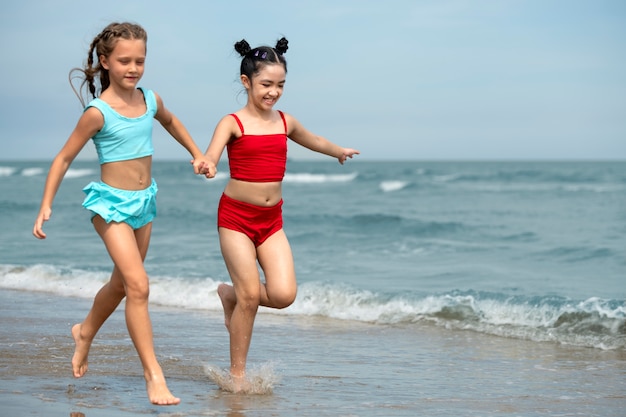 Девушки бегают по пляжу, вид сбоку