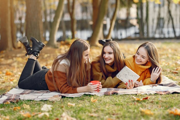 Girls sitting on a blanket in a autumn park