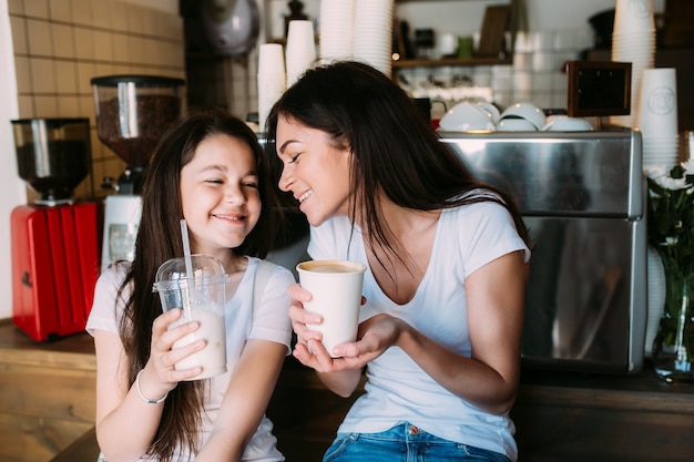 Girls sitting cafe holding cups