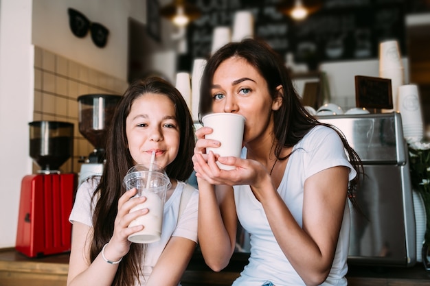 Free photo girls sitting in cafeteria drinking