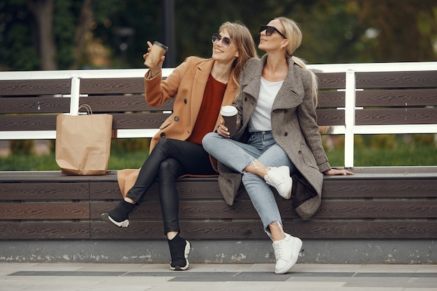 Girls sitting in a spring sity and hold coffee in her hand