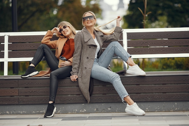 Girls sitting in a spring sity and hold coffee in her hand