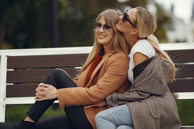 Girls sitting in a spring sity and hold coffee in her hand