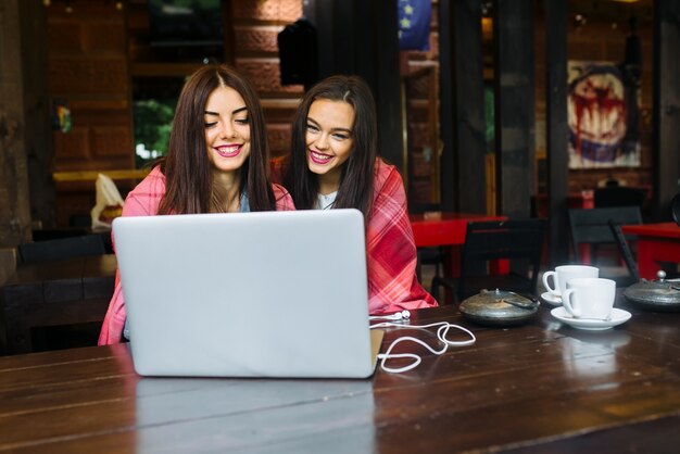 Girls smiling while looking at a laptop