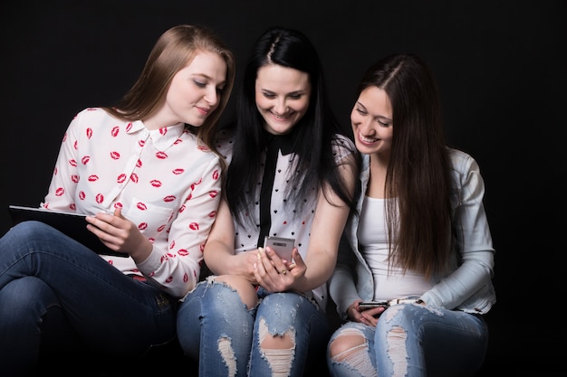 Girls smiling whilen looking at a mobile