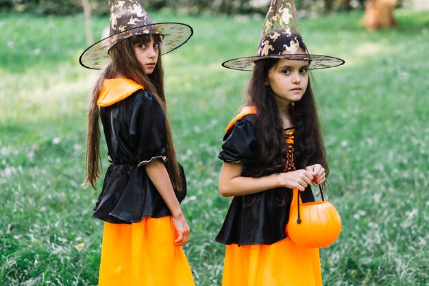 Girls in sorceress costumes poising in park
