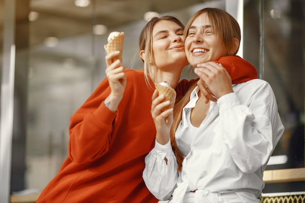 Girls standing in a summer city with ice cream