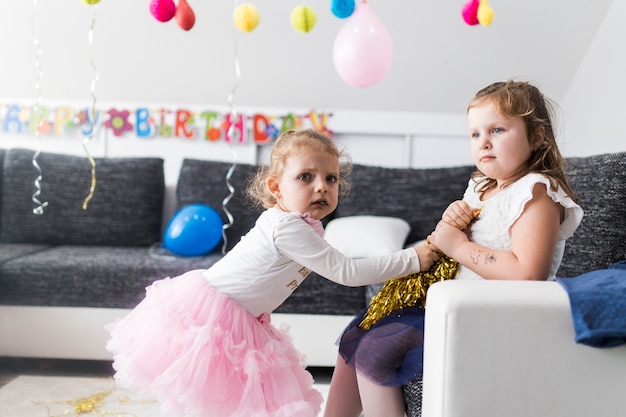 Girls struggling for tinsel on party