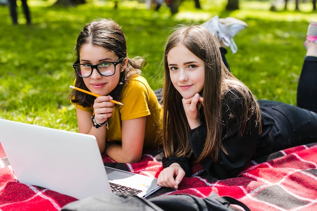 Girls studying and posing on the grass