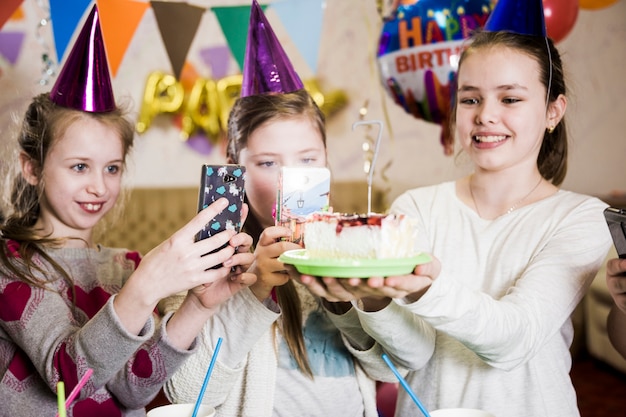 Girls taking pictures of cake