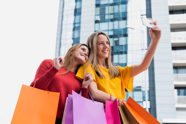 Girls taking selfie after shopping