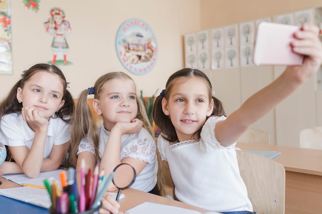 Foto gratuita ragazze che assumono selfie alla scrivania