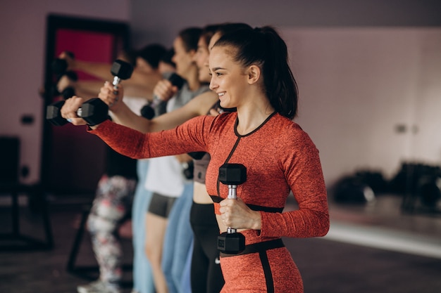 Foto gratuita squadra di ragazze che esercitano insieme aerobica in palestra