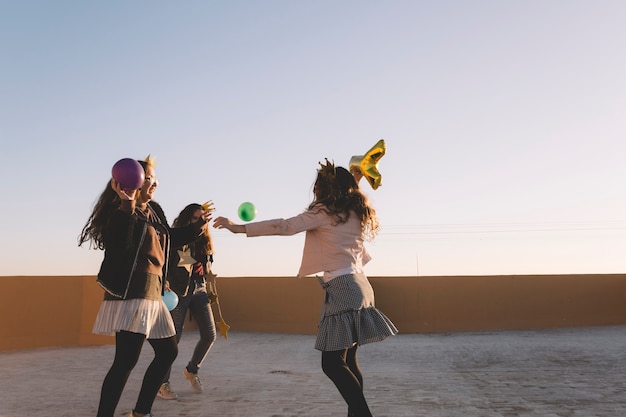 Girls throwing balloons on roof