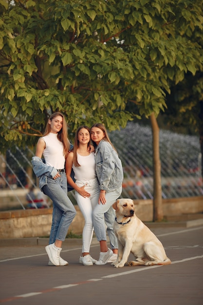 Девушки гуляют в весеннем городе с милой собакой