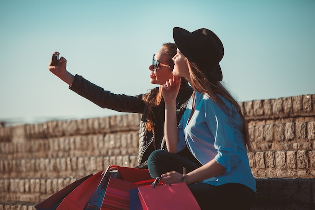 Foto gratuita ragazze che camminano con lo shopping per le strade della città