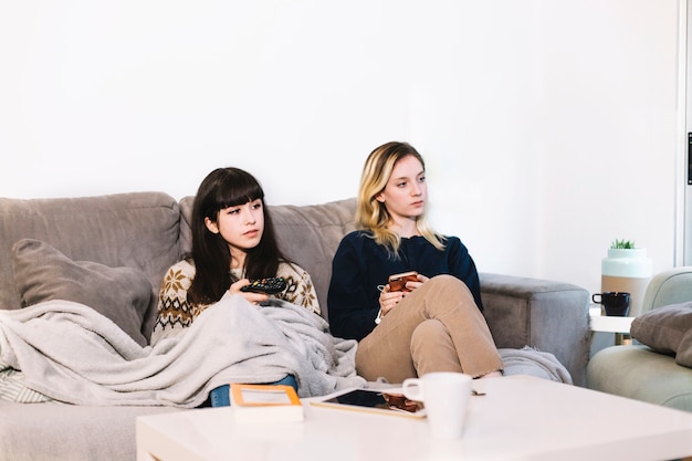 Girls watching TV while chilling on sofa