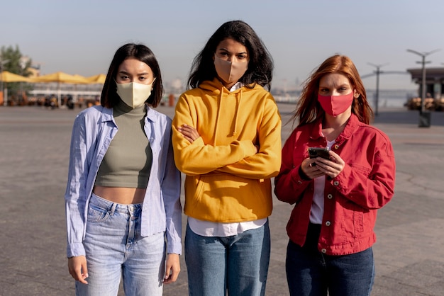 Free photo girls wearing medical masks outside