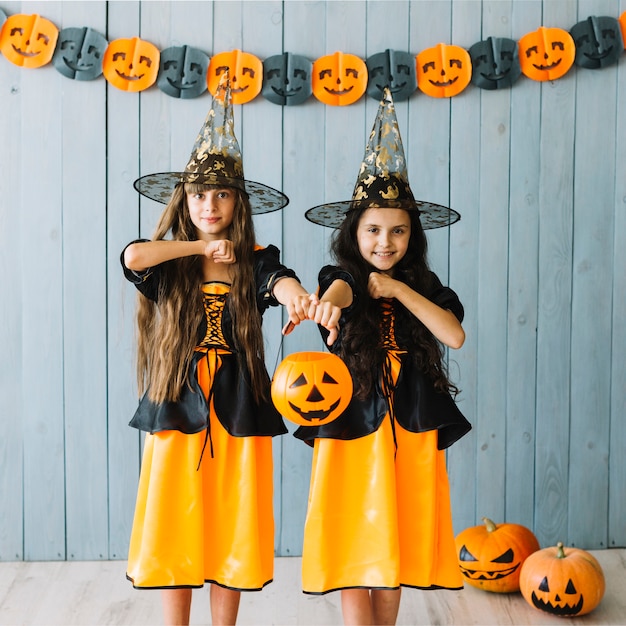 Free photo girls in witch apparel pretending holding knives by necks