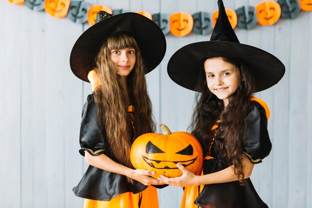 Девушки в костюмах ведьмы с тыквой вместе