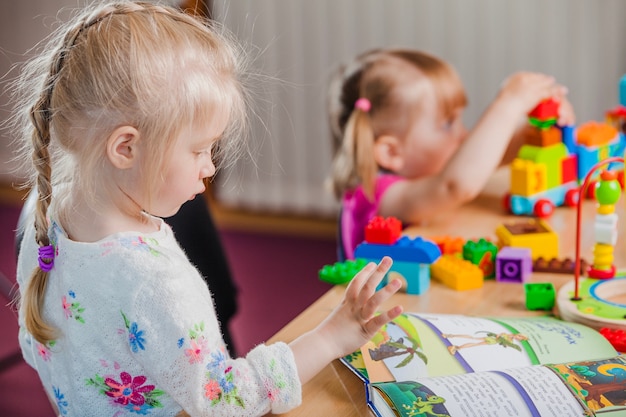 Girls with book and colorful toys