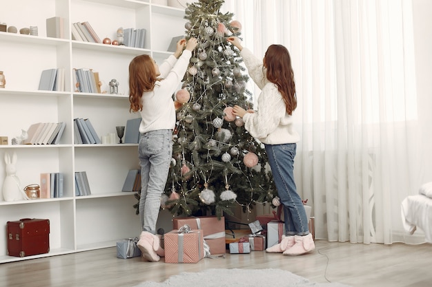 Girls with Christmas toys. Women at home. Sisters are preparing for holidays.