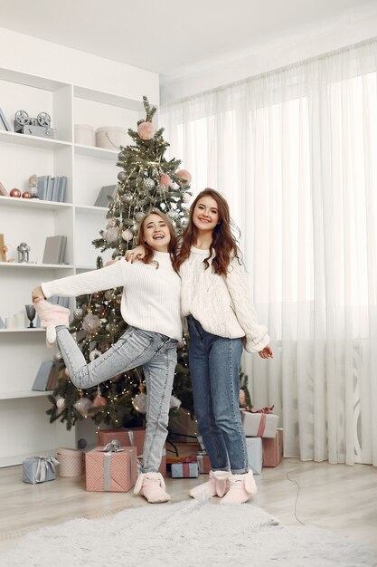 Girls with Christmas toys. Women at home. Sisters are preparing for holidays.