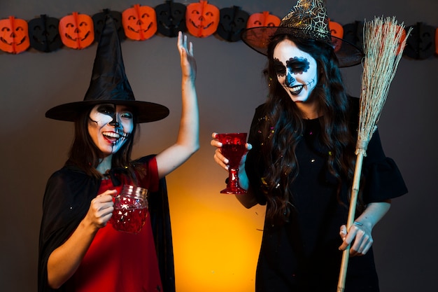 Ragazze con le bevande in una festa di Halloween