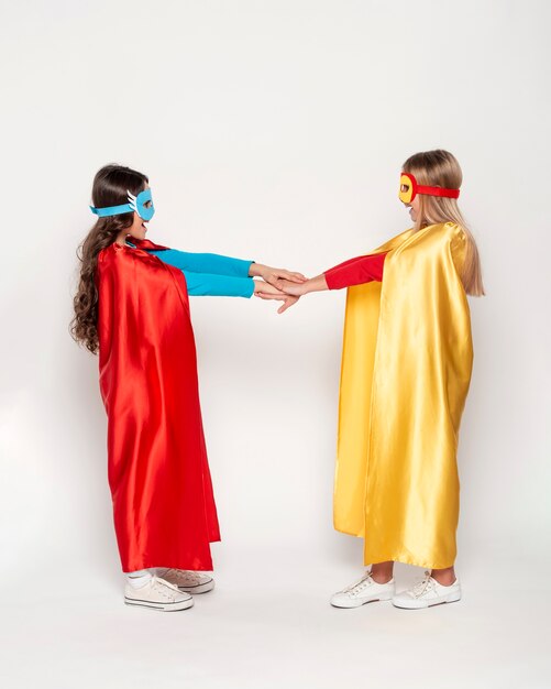 Girls with heros costume holding hands