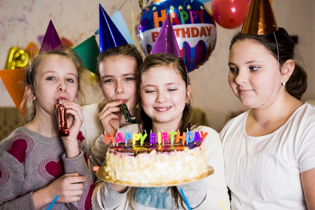 Girls with party horns and cake