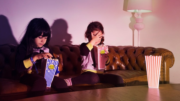 Девушки с попкорном на диване