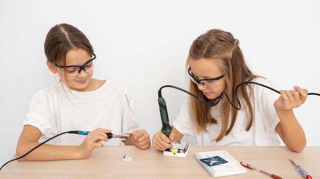 Foto gratuita ragazze con occhiali protettivi che fanno insieme esperimenti scientifici