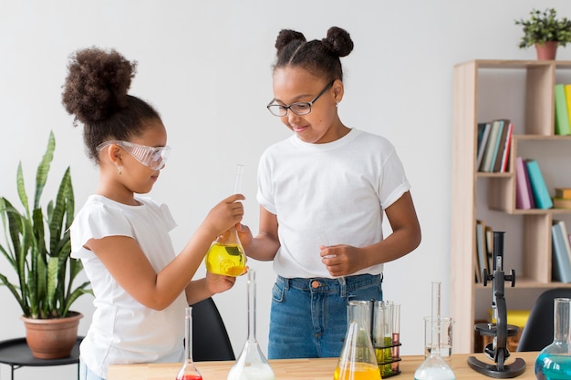 Foto gratuita ragazze con occhiali di sicurezza che fanno esperimenti di chimica