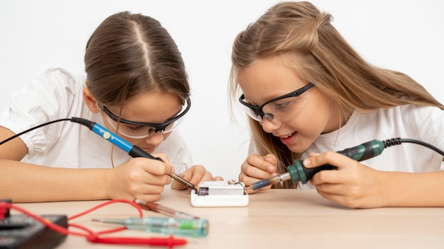 Девушки в защитных очках вместе проводят научные эксперименты