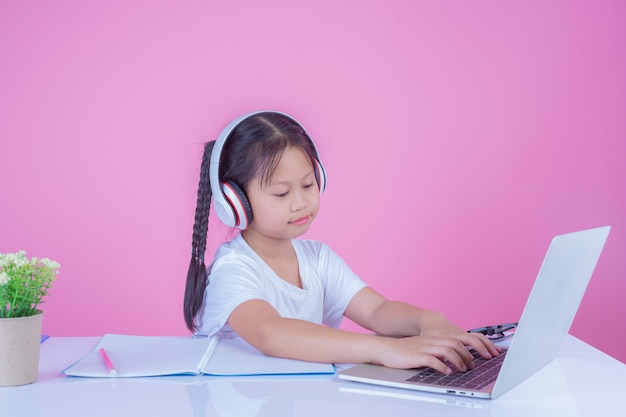 Girls write books on a pink background.