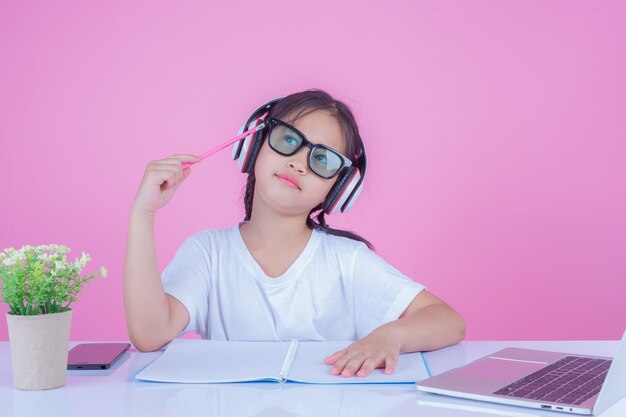 Girls write books on a pink background.