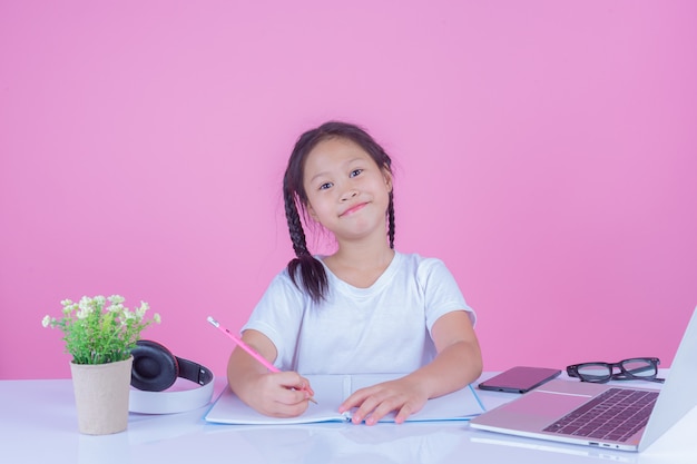 Girls write books on a pink background.