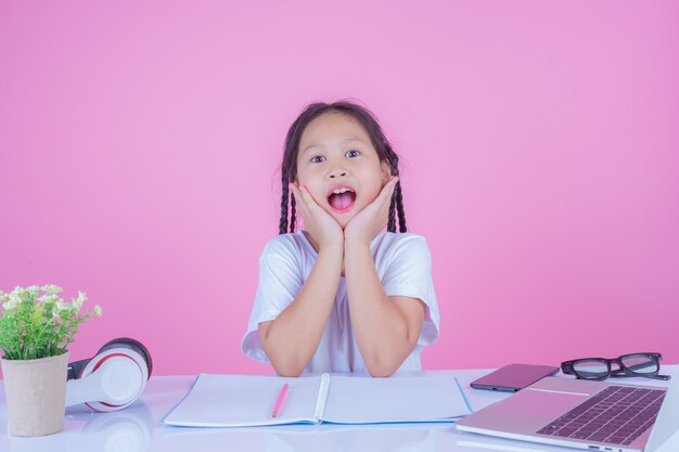 Girls write books on a pink background.