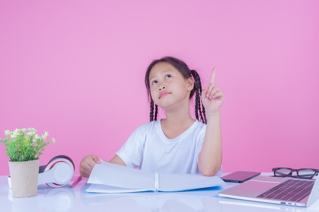 Girls write books on a pink background.