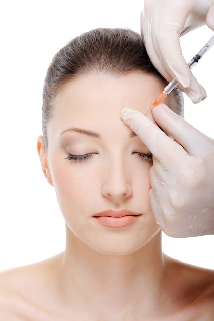 Giving an injection in the eyebrow on the female face - white space