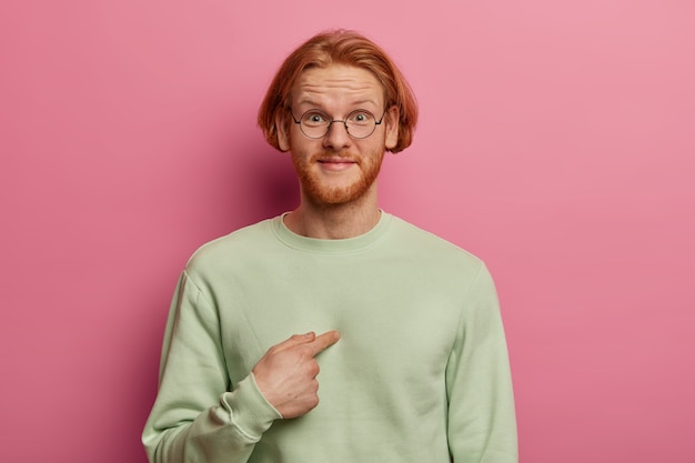 Glad bearded guy with ginger hair and beard points at himself