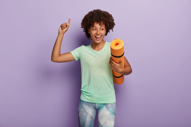 Glad dark skinned woman attends fitness class