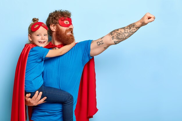 Glad family being heroic leaders, wear superhero costumes