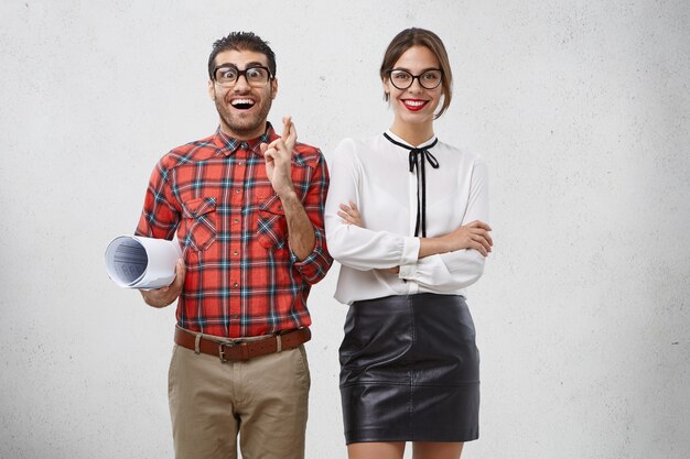 Glad hopeful male geek or wonk keeps fingers crossed, worries before presentation of new project