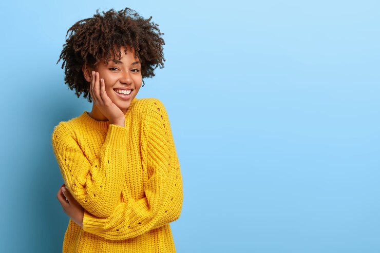 Free Photo glad woman with an afro posing in a pink sweater